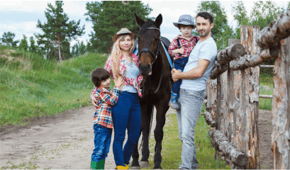 A full family outdoors by the wooden gate with their horse. A picture brought to you by Minus Bite